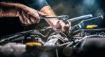 Recall Repair - Auto mechanic working on car engine in mechanics garage. Repair service. authentic close-up shot